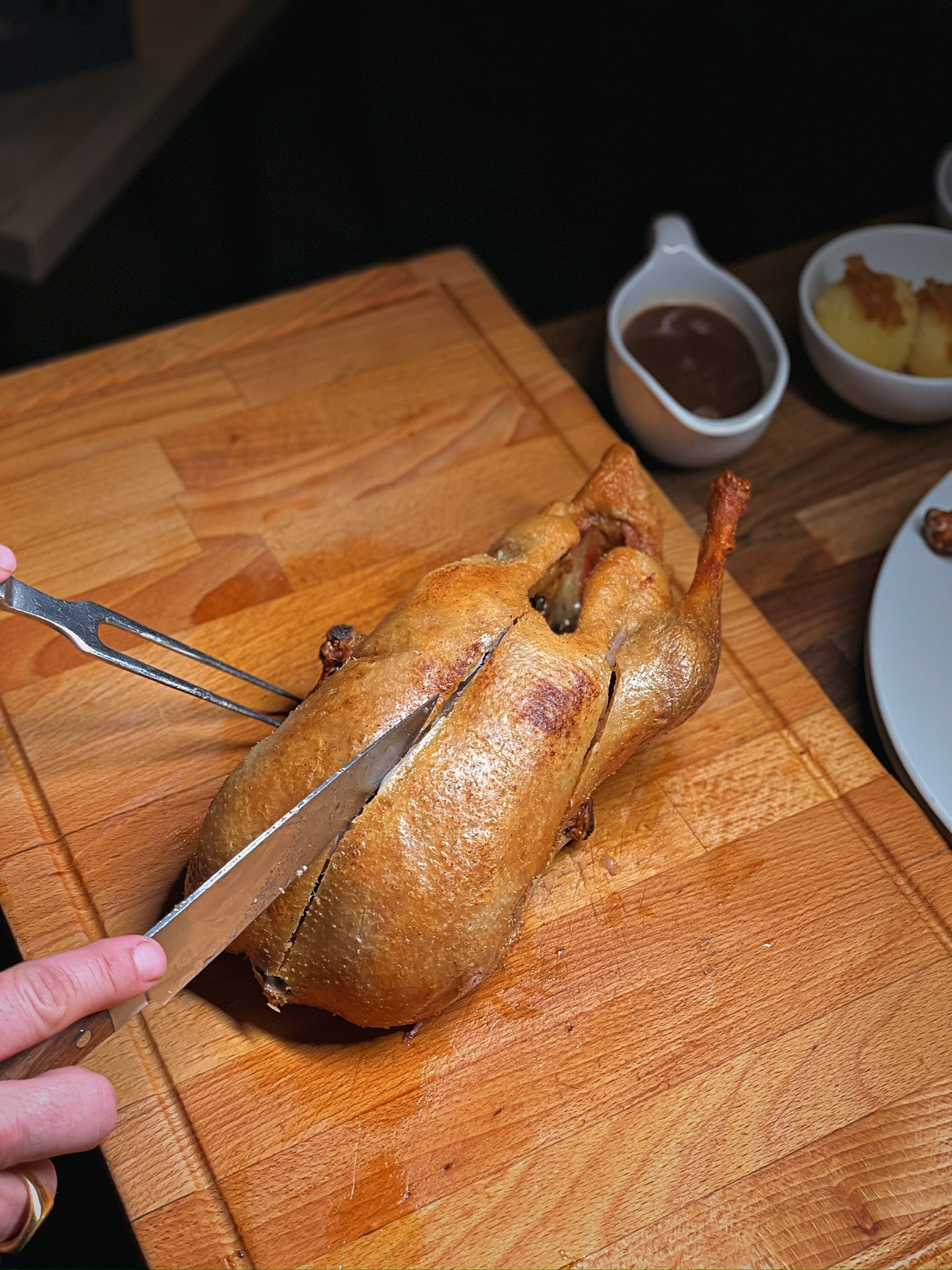 Duckman Ente wird am Tisch tranchiert – Messer, knusprige Ente und Sauciere